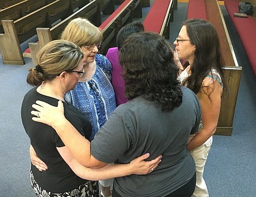 Women connected in prayer.
